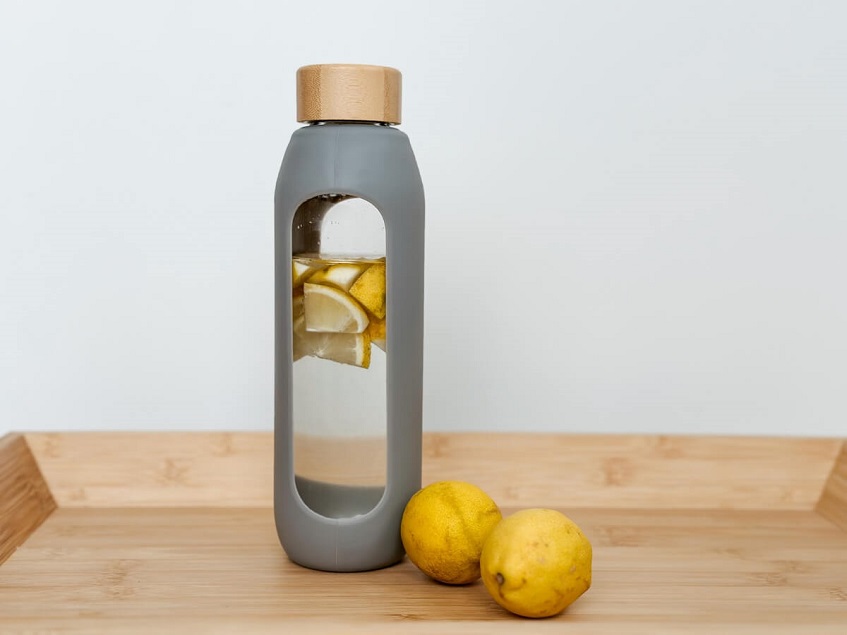 Fľaša vody s nakrájaným citrónom.