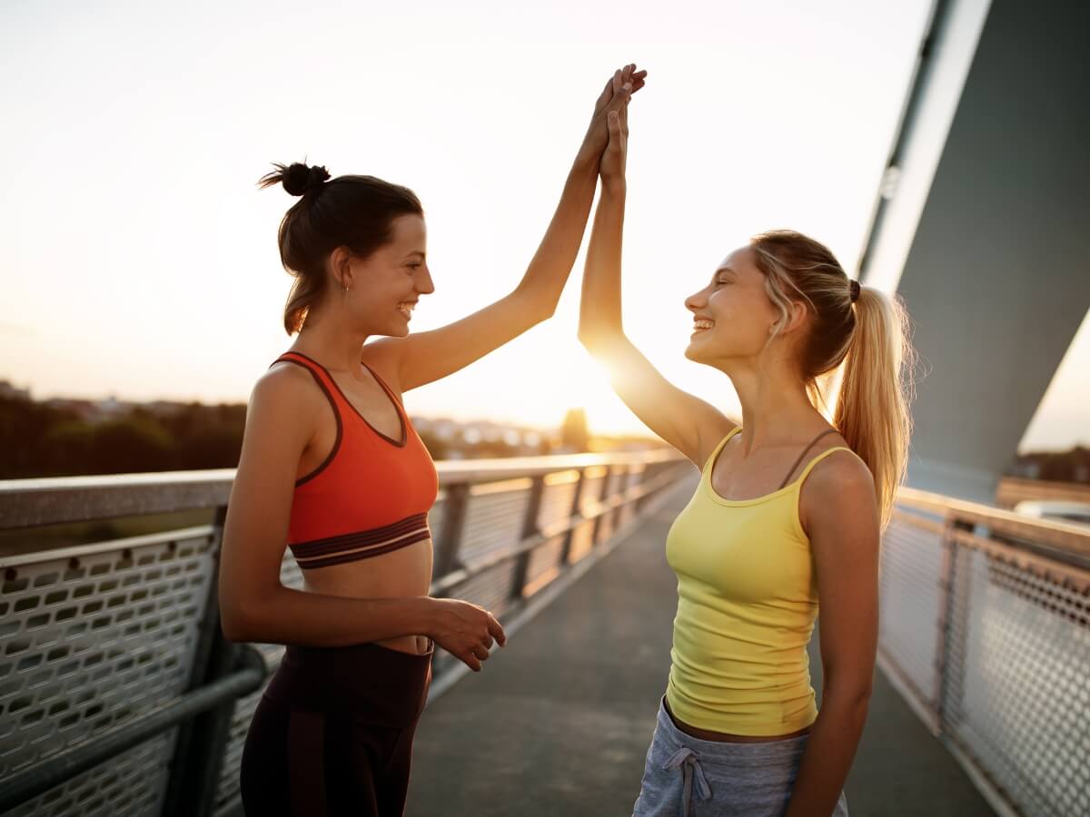 Kamarátky po športe v dobrej nálade na moste.